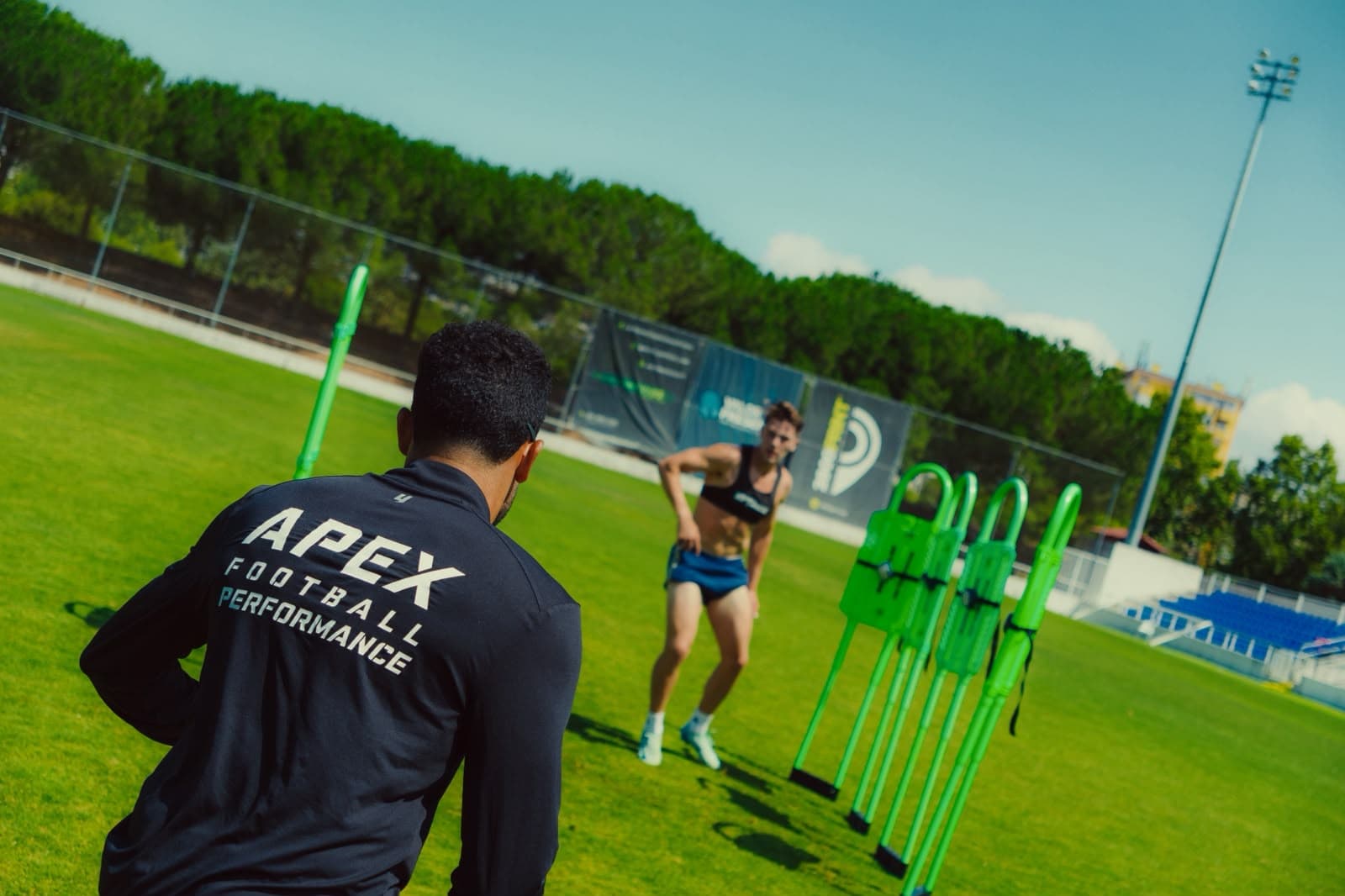 Apex coach leading an agility mannequin drill with a professional footballer